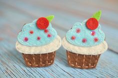 two felt cupcakes with blue icing and sprinkles on them