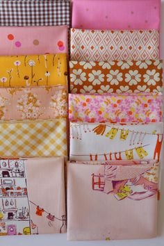 several different types of fabric are arranged in a row on a white surface, including pink, yellow and orange