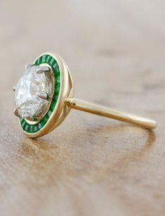 If you want old world charm with touches of deep green throughout the design - something fit for royalty - then you have found it in our Andora. We sourced a gorgeous 2.50ct brilliant round diamond for the center and sprinkled green emeralds that were custom cut to fit each and every nook and cranny of this beautiful halo ring. Setting cost only below:14k Rose, White, or Yellow Gold setting $9850 18k Rose, White, or Yellow Gold setting $10,100Platinum setting $10,350 This ring is not returnable, and requires up to 6 months for fabrication. Round Ring With Halo, Old Miners Cut Engagement Ring, Unique Colorful Engagement Rings, 1 Carat Engagement Ring Round, Halo Engagement Ring Emerald, Ring Upgrade, Halo Ring Setting, Round Halo Engagement Rings, Vintage Inspired Rings