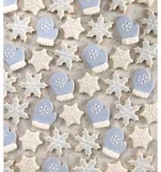 snowflakes and mittens decorated cookies on a table