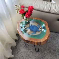 a small table with flowers on it in front of a couch