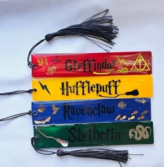 four harry potter bookmarks with tassels attached to them on a white surface