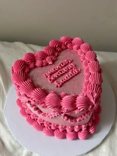 a pink heart shaped cake on a white plate