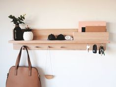 a purse hanging on a wall next to a shelf with keys and other items in it