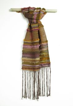 a scarf with fringes hanging on a wall