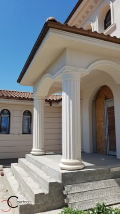 a white house with columns and steps leading to the front door