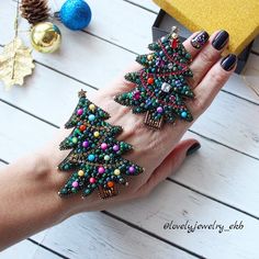 a woman's hand with beaded christmas tree bracelets on her left wrist