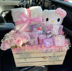 a hello kitty gift basket in the back seat of a car filled with pink flowers