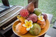 a bowl filled with fruit sitting on top of a table