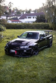 a black car parked on top of a lush green field