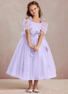 Shaylee is an enchanting A-line flower girl dress that is crafted from delicate tulle. She features intricately handmade 3D flower embellishments. Off-shoulder sleeves offer a touch of whimsy that is complimented with a tulle bow back. The flowers cascade gracefully down the tulle skirt that flows with every step. Lilac Flower Girl Dresses, Purple Flower Girls, Purple Flower Girl Dress, Taylor Outfits, Tulle Bow, Flower Embellishments, Tulle Flower Girl, Tulle Bows, Line Flower