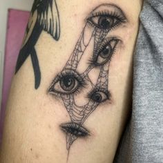 a close up of a person's arm with an eye and spider web on it