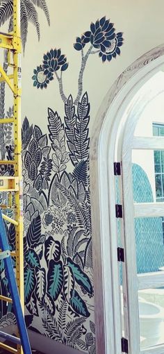 a ladder is in front of a wall mural