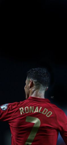 a man holding a soccer ball in his right hand and wearing a red shirt with the number 7 on it