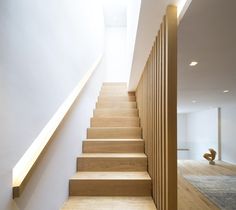 the stairs are made of wood and have white walls