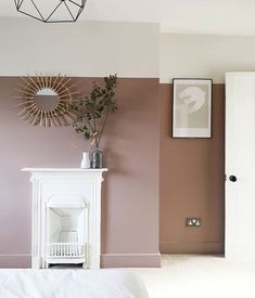 there is a fireplace in the corner of this room with pink walls and white furniture