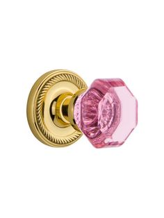 a pink glass door knob on a gold plated brass finish cabinet or drawer handle