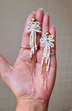 "Handmade statement Ivory pearl and gold chain floral long earrings. These handmade statement earrings are made of faux pearl flower, seed beads, and electroplated rose gold chain. The earrings are beautiful and ideal for weddings and parties. The earrings measures approx. 3\" long and 1.50\" wide. Carnation jewellery are purely handmade & handcrafted in India. Since our product is purely handmade in nature hence a slight imperfection may be there but it is almost negligible. The colors and may Statement Beaded Earrings, Gold Tassel Earrings For Wedding, White Chandelier Earrings With Pearl Chain For Party, Elegant Gold Flower Earrings With Dangling Beads, Elegant Fringe Jewelry For Weddings, Elegant Fringed Jewelry For Weddings, Elegant Tassel Earrings With Dangling Beads For Wedding, Elegant Wedding Tassel Earrings With Dangling Beads, Elegant Wedding Tassel Earrings With Latkans