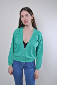 Add a touch of vintage charm to your wardrobe with this green minimalist buttons cardigan! Made from comfortable cotton, this cardigan features a unique design that is perfect for adding a retro flair to your outfit. Please note that this is a vintage item, so it may have some defects. To ensure a proper fit, please refer to the measurements below: Sleeve: 46cm / 18.11 inches (measured from armpit to end of sleeve) Width: 52cm / 20.47 inches Length: 52cm / 20.47 inches These measurements are tak Vintage V-neck Cardigan For Layering, Retro Green V-neck Sweater, Trendy Green Cardigan For Layering, Green V-neck Cardigan For Layering, Green Cotton V-neck Cardigan, Green Cotton Long Sleeve Cardigan, Green Cotton Sweater With Button Closure, Green Button-up Cotton Cardigan, Vintage Sweater For Spring Layering