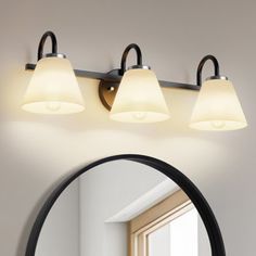 a bathroom light with three lights on it and a mirror in front of the wall