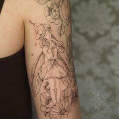 a woman with a tattoo on her arm holding onto a flower and an apple blossom