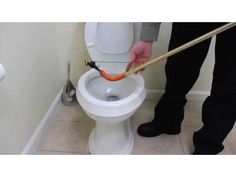 a person using a plunger to clean a toilet