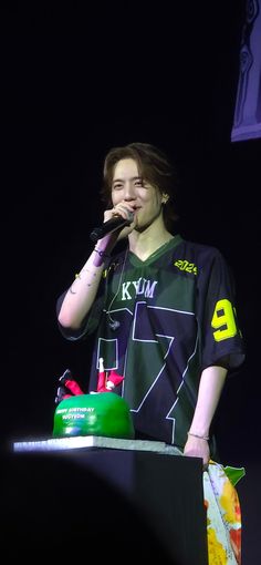 a young man standing at a podium holding a microphone