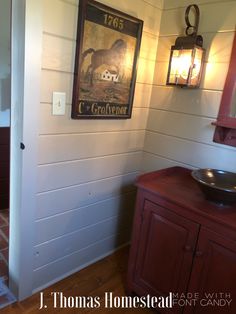 a bathroom with a painting on the wall and a wooden cabinet in front of it