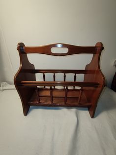 a wooden bed frame sitting on top of a white sheet