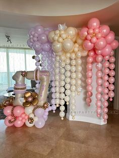 some balloons are hanging from the ceiling in front of a table and chair with other decorations