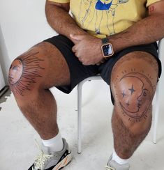 a man sitting in a chair with tattoos on his legs