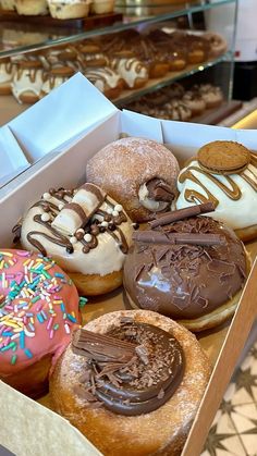 a box filled with lots of different flavored donuts