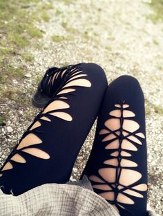 the legs of a woman wearing black leggings with cut out holes on them