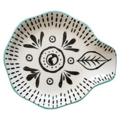 a white and black plate with an arrow design on the side, sitting in front of a white background