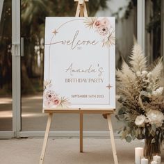 a welcome sign with flowers and candles in front of the entrance to an outdoor venue