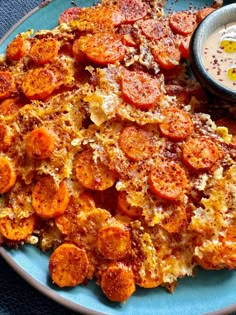 a blue plate topped with food next to a bowl of dip