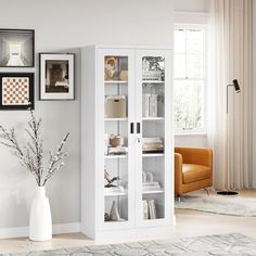 a white bookcase in a living room with pictures on the wall