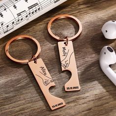 two keychains that have been engraved with the names of people and music notes on them