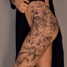 a woman is showing off her thigh with flowers and birds tattoo on it's side