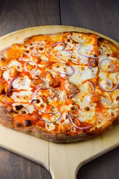 a pizza sitting on top of a cutting board covered in cheese and onion toppings