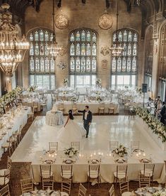 a bride and groom standing on top of a dance floor surrounded by tables with white linens