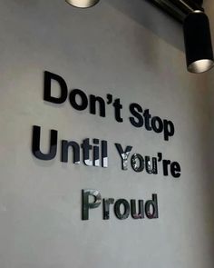 a sign that says don't stop until you're proud on the wall