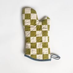 an oven mitt made out of green and white checkerboard fabric on a white background