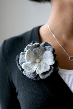 a woman wearing a necklace with a flower on it