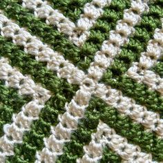 close up view of the crochet stitchs on a green and white blanket