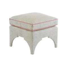 a white ottoman with a blue and pink pattern on the top, sitting in front of a