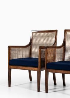 two wooden chairs with blue cushions sit side by side