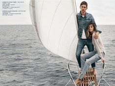 two people on a sailboat in the ocean posing for a magazine advertise