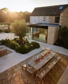 a wooden table sitting in the middle of a garden next to a building and trees