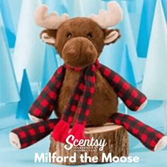 a stuffed moose sitting on top of a tree stump with a scarf around it's neck